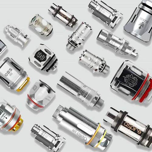 Assorted vape coils and replacement heads for e-cigarettes on a white background, vapeswholesale